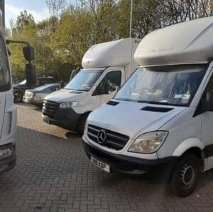 Fleet of white moving vans parked in a lot ready for relocation services