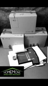 Packed moving boxes labeled fragile with protective materials and framed shirt