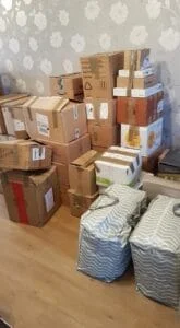 Stack of moving boxes and striped storage bags in a room ready for relocation